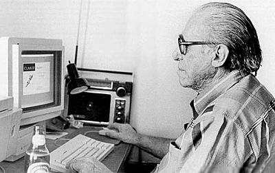A black-and-white photo of a man using a computer